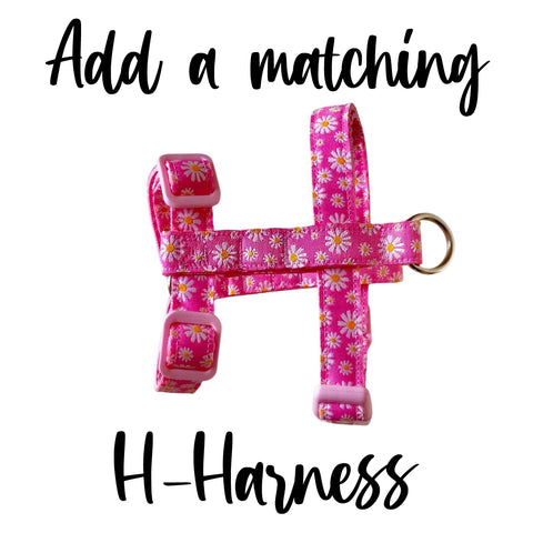 Dog harness featuring a pink ribbon with yellow and white daisies. Has the words 'Add a matching H-Harness'.