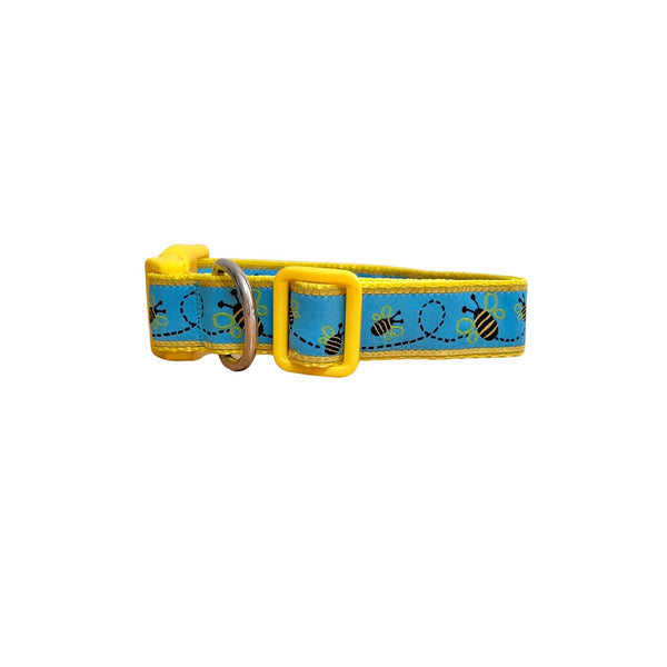 Dog collar featuring a blue ribbon with bumble bee theme on yellow webbing.