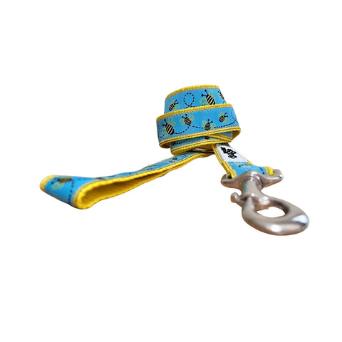 Dog leash featuring a blue ribbon with bumble bee theme on yellow webbing.