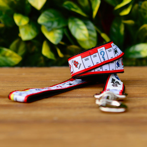 Dog leash featuring a white ribbon with Monopoly pattern, on black webbing. 