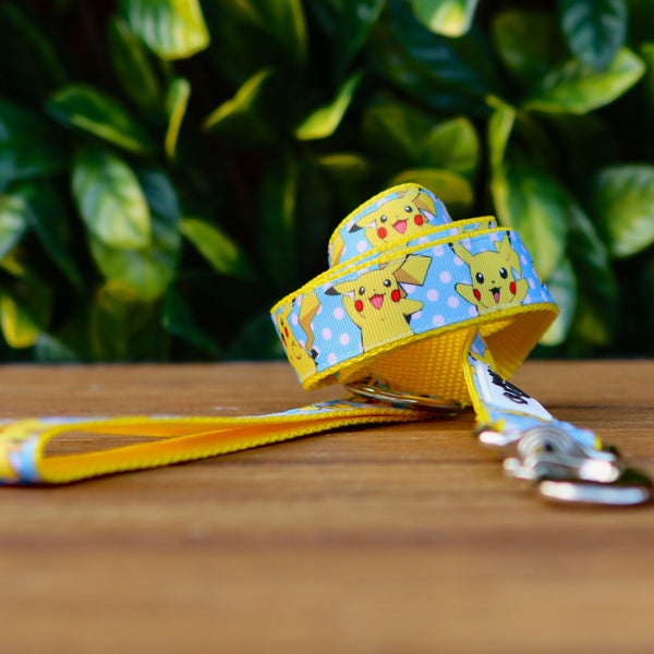 Dog leash featuring a blue ribbon with Pikachu pattern, on yellow webbing. 
