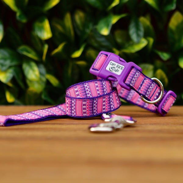 Dog collar and leash featuring a vibrant pink and purple Aztec themed ribbon on purple webbing.