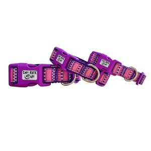 Three dog collars featuring a vibrant pink and purple Aztec themed ribbon. The collars have purple webbing and buckles.